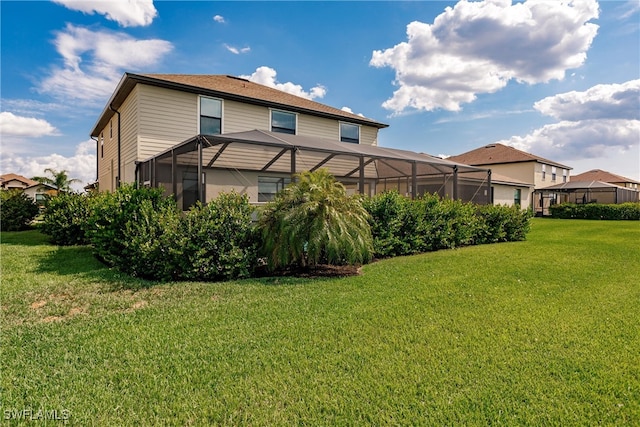 back of property featuring a lanai and a yard