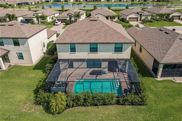 view of swimming pool with a lanai, a water view, and a lawn