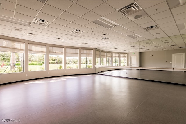 unfurnished room featuring a drop ceiling and a healthy amount of sunlight