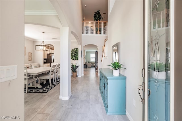 foyer entrance featuring an inviting chandelier and ornamental molding