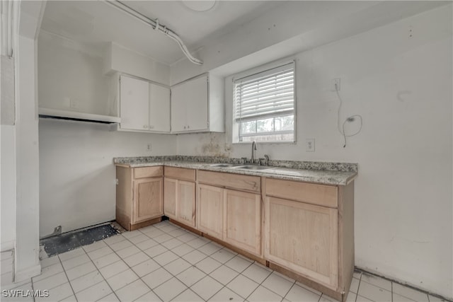 kitchen featuring light tile patterned flooring, light brown cabinets, and sink