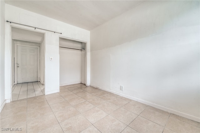 unfurnished bedroom with a closet and light tile patterned floors