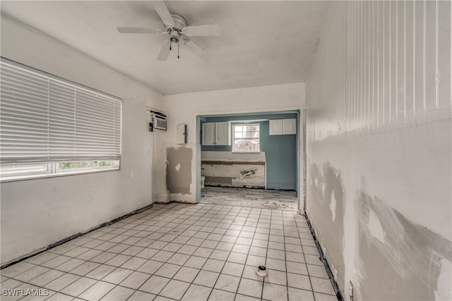 unfurnished room with ceiling fan, a wealth of natural light, a wall mounted air conditioner, and light tile patterned floors