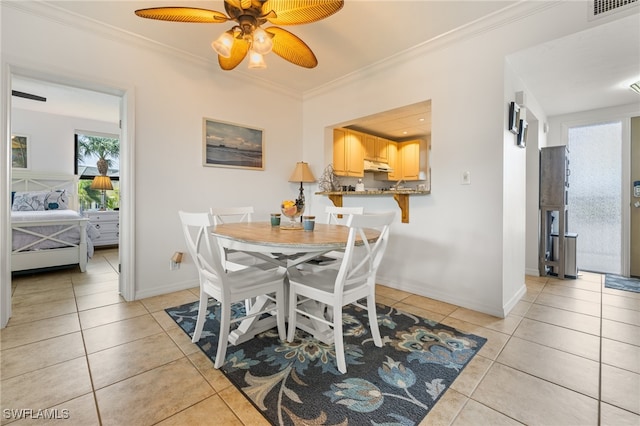 tiled dining area featuring crown molding and ceiling fan