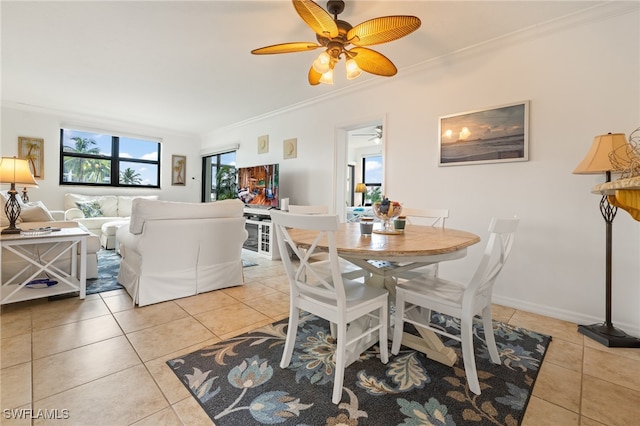 tiled dining area with ornamental molding and ceiling fan