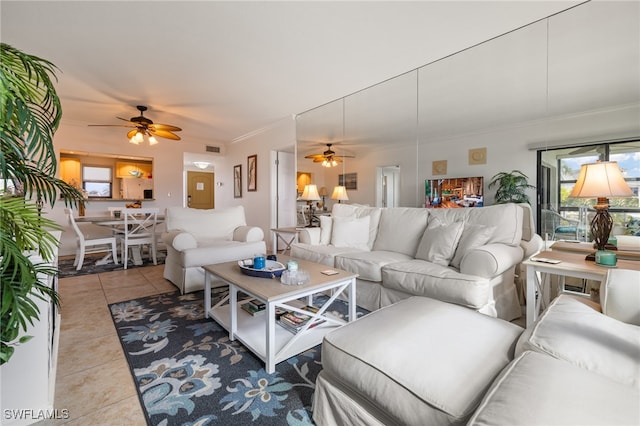 living room featuring ceiling fan, light tile patterned floors, and crown molding