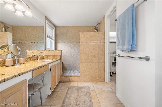 bathroom featuring a tile shower, tile patterned flooring, and vanity