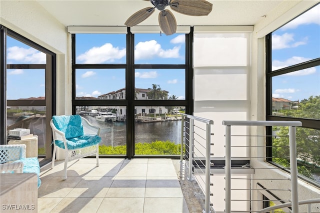 sunroom / solarium featuring a water view and ceiling fan