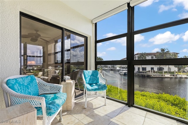 sunroom / solarium featuring a water view and ceiling fan