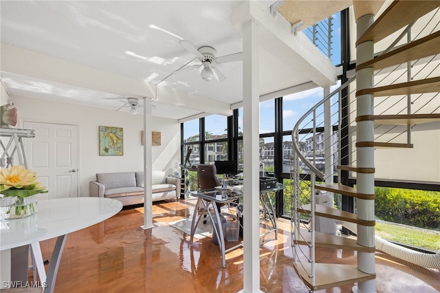 interior space featuring ceiling fan and a wall of windows