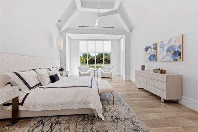 bedroom with light wood-type flooring, a towering ceiling, and baseboards