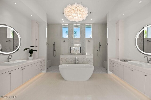 bathroom with a freestanding tub, walk in shower, a sink, and a wealth of natural light