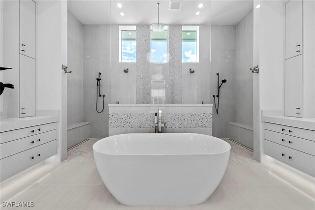 bathroom with a walk in shower, a soaking tub, vanity, and visible vents