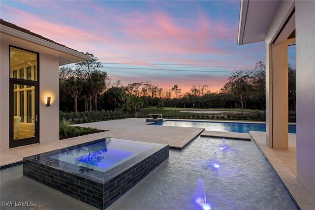 pool featuring a patio area and an in ground hot tub