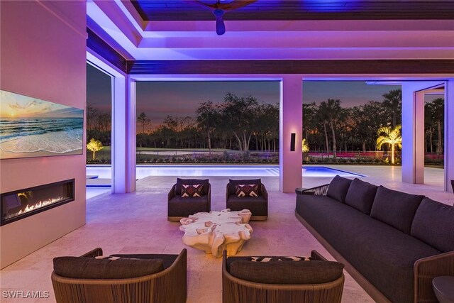 patio terrace at dusk with an outdoor living space with a fireplace