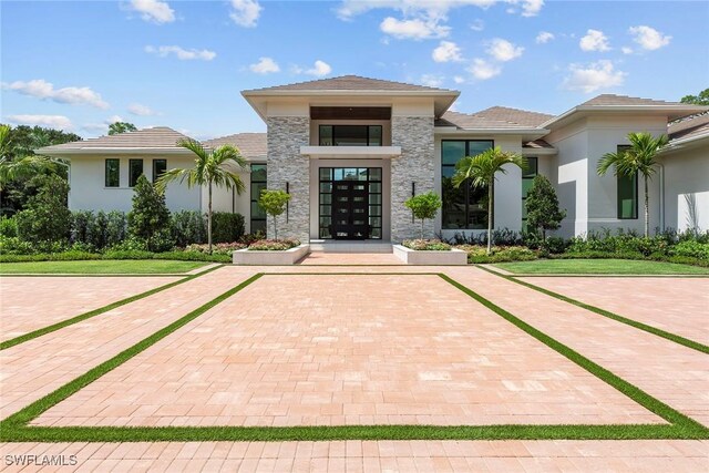 view of exterior entry with stone siding and stucco siding