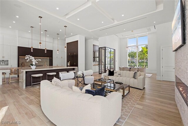 living area featuring light wood-type flooring, a high ceiling, and recessed lighting