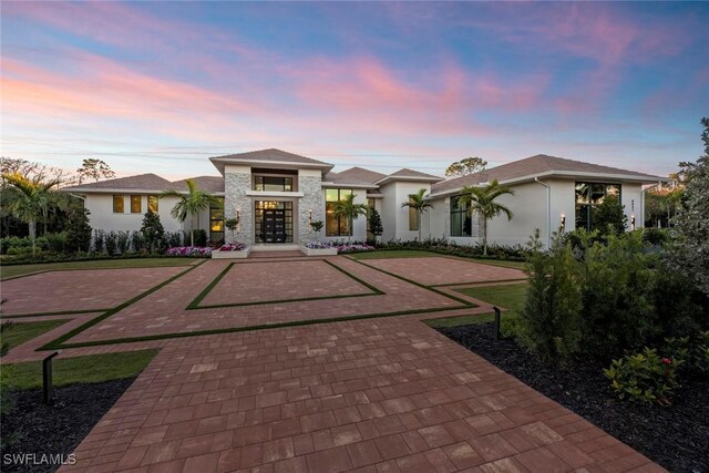 view of front of house featuring decorative driveway and stucco siding