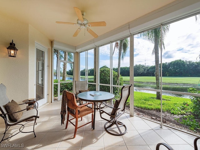 sunroom featuring a water view, ceiling fan, and a healthy amount of sunlight