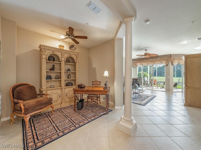 living area featuring ornate columns, light tile patterned floors, and ceiling fan