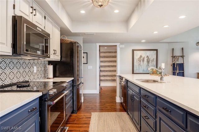 kitchen with blue cabinetry, sink, appliances with stainless steel finishes, white cabinets, and hardwood / wood-style flooring