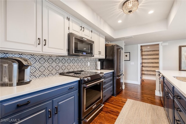 kitchen with dark hardwood / wood-style flooring, white cabinetry, blue cabinets, and appliances with stainless steel finishes