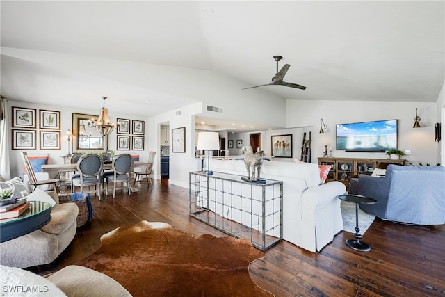 living room with ceiling fan with notable chandelier, dark hardwood / wood-style floors, and vaulted ceiling