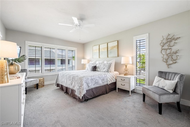 bedroom with light carpet, multiple windows, and ceiling fan