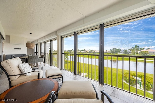 sunroom / solarium featuring a water view and a wall unit AC