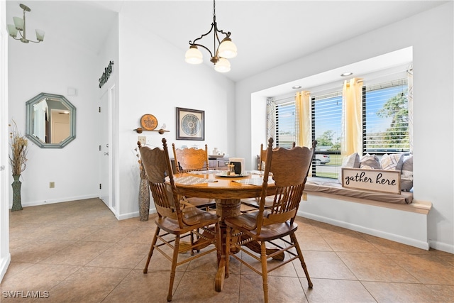 tiled dining space featuring a notable chandelier and vaulted ceiling