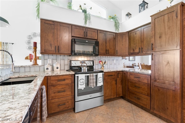 kitchen featuring electric stove, sink, light stone counters, and light tile patterned floors