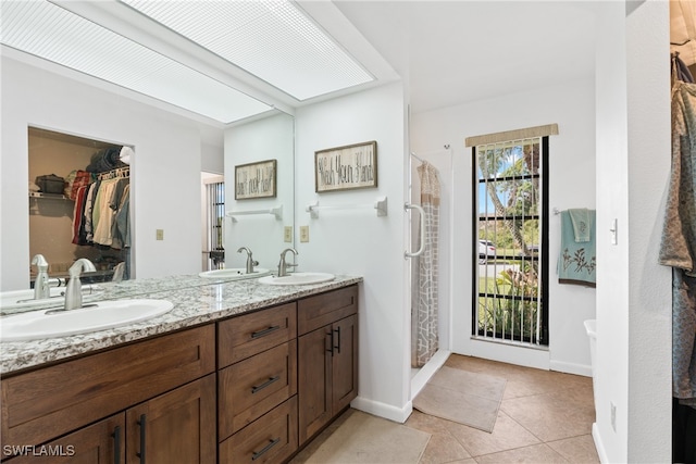 bathroom with vanity, walk in shower, and tile patterned flooring