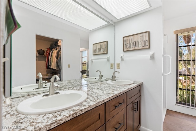 bathroom featuring vanity, tile patterned floors, and a skylight