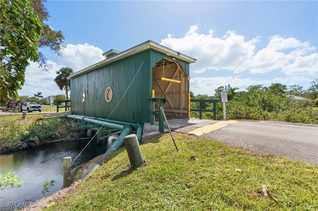 view of home's exterior with a yard and a water view