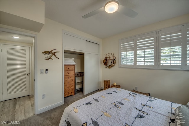 bedroom featuring hardwood / wood-style flooring, ceiling fan, and a closet