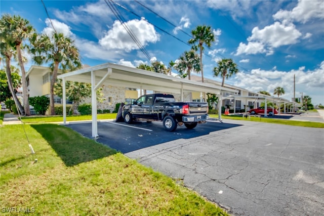 view of parking with a carport and a yard