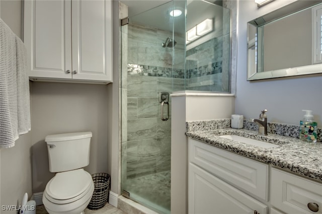 bathroom with vanity, toilet, and a shower with shower door