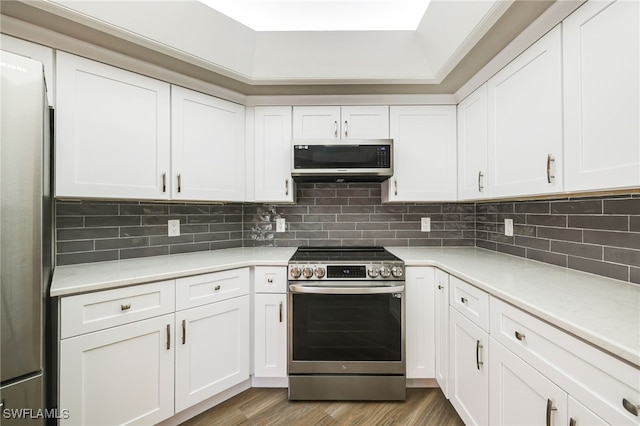 17585 Blackfriar Dr, Fort Myers, FL 33908 - kitchen with white cabinetry, tasteful backsplash, appliances with stainless steel finishes, and light wood-type flooring