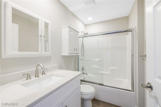 17585 Blackfriar Dr, Fort Myers, FL 33908 - full bathroom featuring vanity, shower / bath combination with glass door, toilet, and hardwood / wood-style flooring