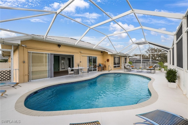 view of swimming pool featuring a patio and a lanai