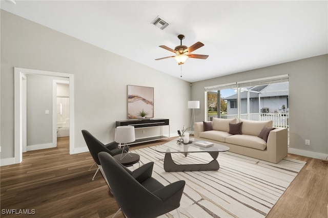 living room with hardwood / wood-style floors, vaulted ceiling, and ceiling fan