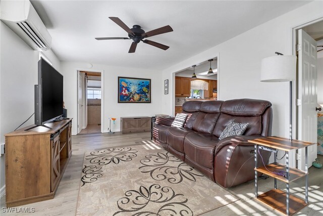 living room featuring ceiling fan, light hardwood / wood-style flooring, and a wall mounted air conditioner