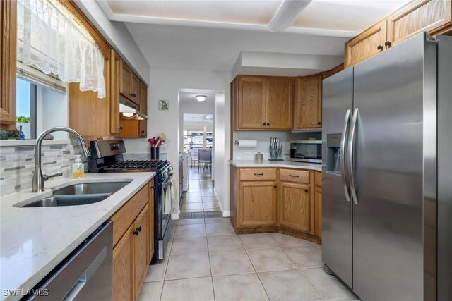 kitchen with stainless steel appliances, sink, tasteful backsplash, and a wealth of natural light