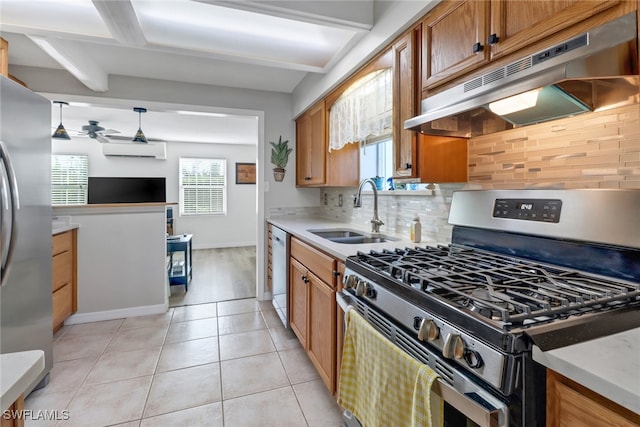 kitchen featuring hanging light fixtures, light tile patterned floors, sink, tasteful backsplash, and appliances with stainless steel finishes