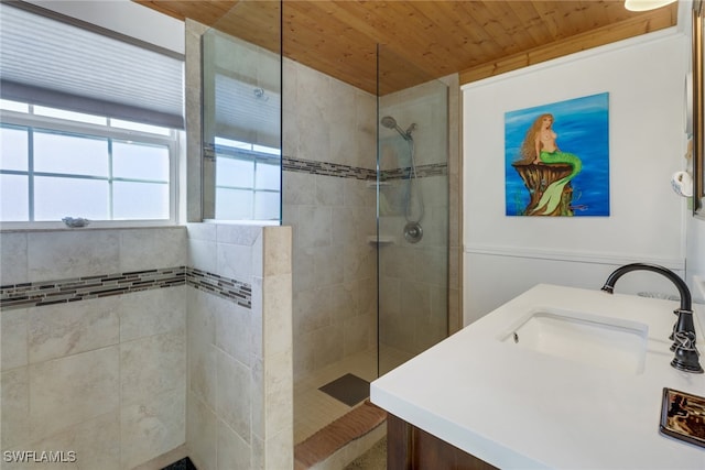 bathroom featuring vanity, a tile shower, and wooden ceiling