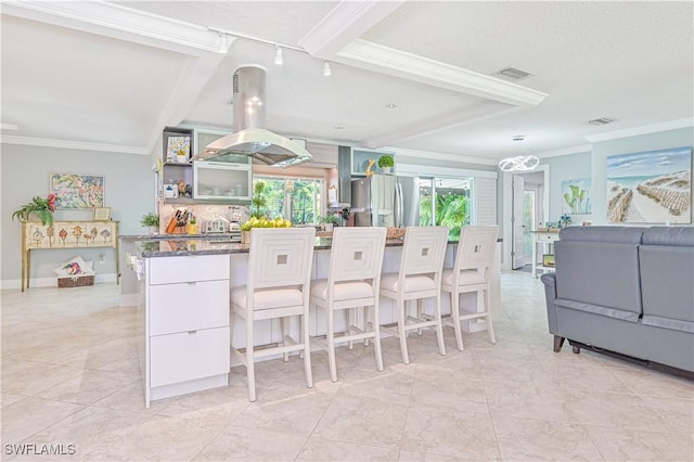 kitchen with stainless steel refrigerator with ice dispenser, ornamental molding, and island range hood