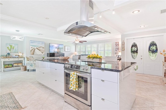 kitchen featuring stainless steel range with electric cooktop, island range hood, track lighting, white cabinets, and a center island