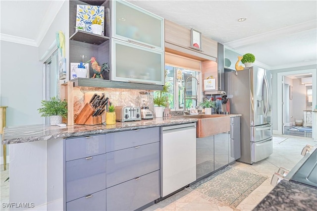 interior space featuring light tile patterned floors, kitchen peninsula, appliances with stainless steel finishes, dark stone counters, and ornamental molding