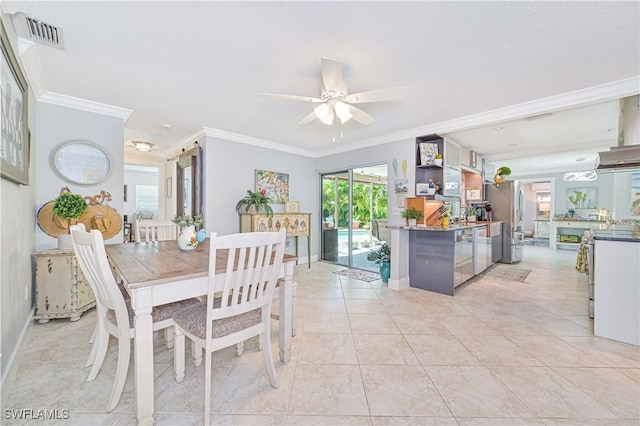 dining area with ceiling fan, ornamental molding, and light tile patterned flooring