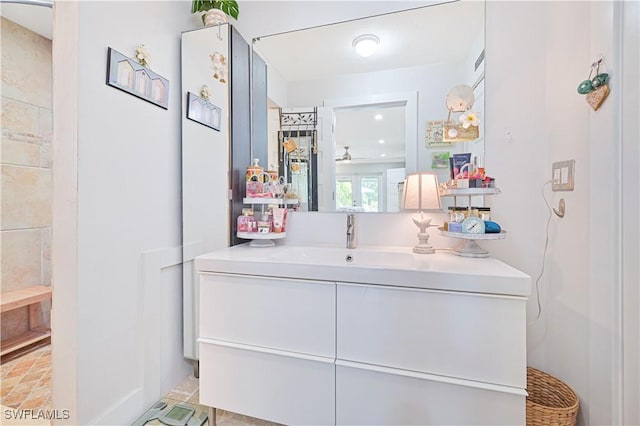 bathroom with ceiling fan, vanity, and a shower